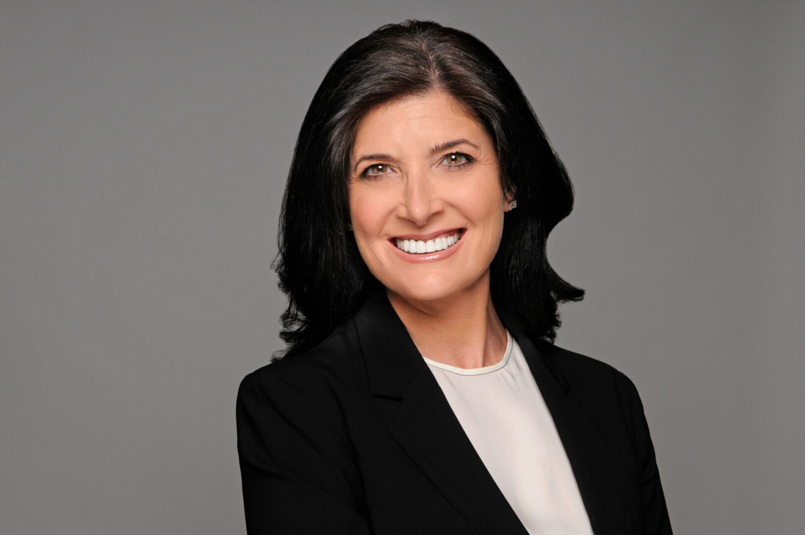 A woman in black jacket smiling for the camera.